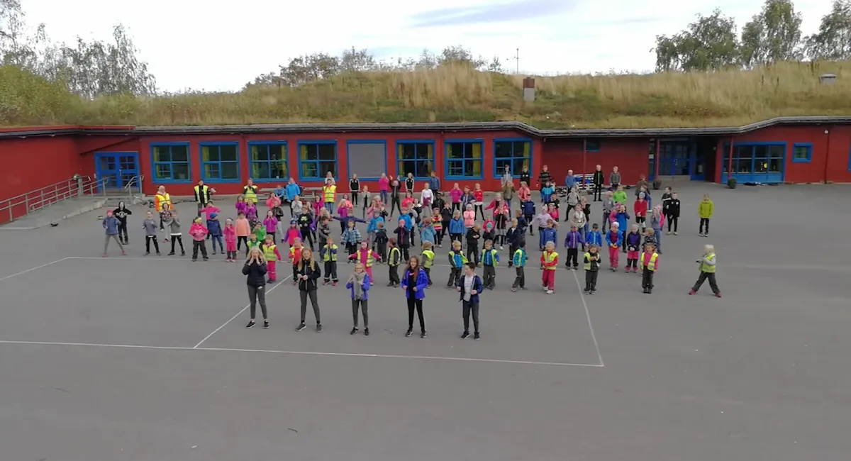 Elever danser bli-med-dansen foran Rye skole