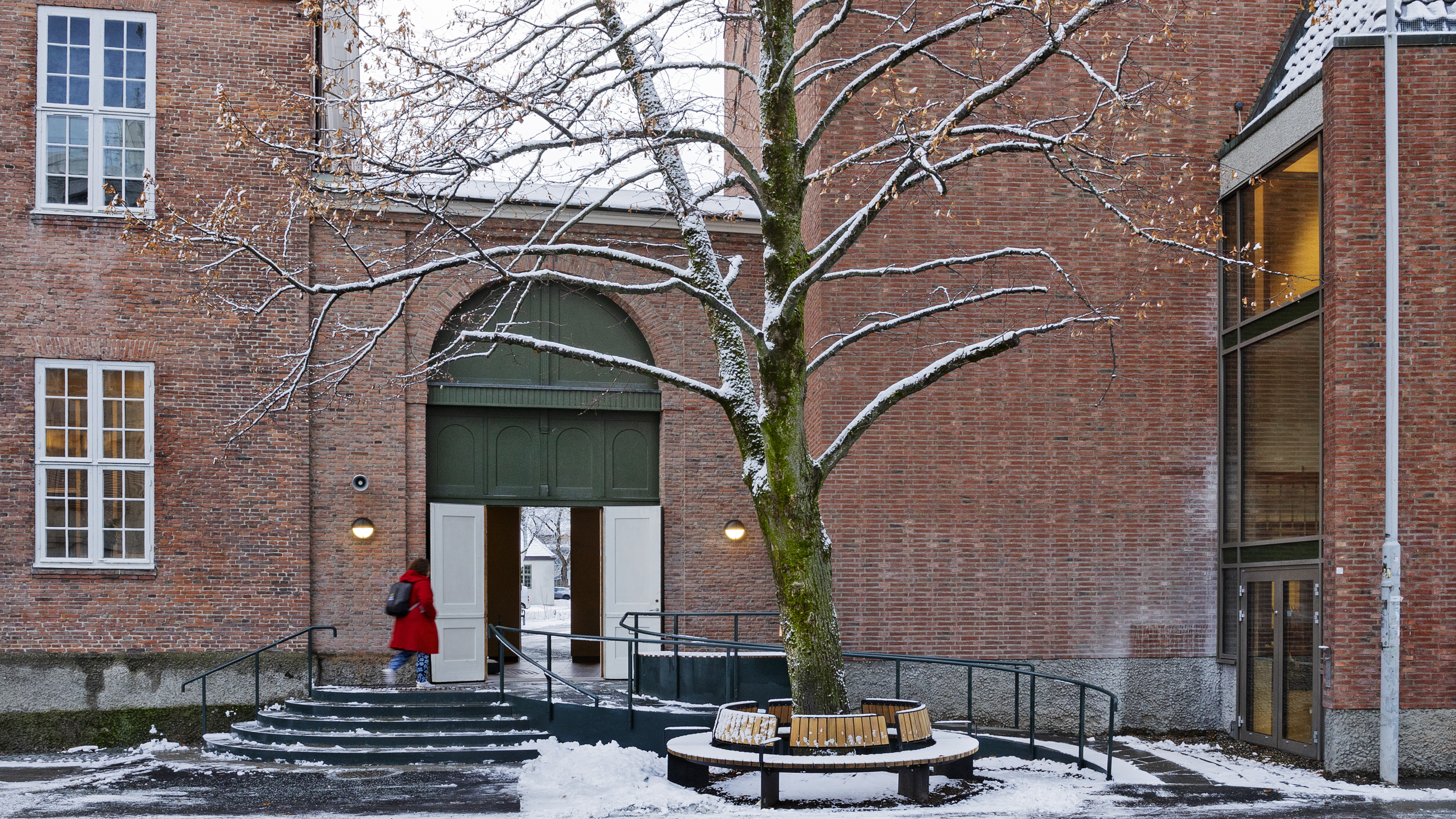 rampe og trapp foran passasje mellom to teglbygninger