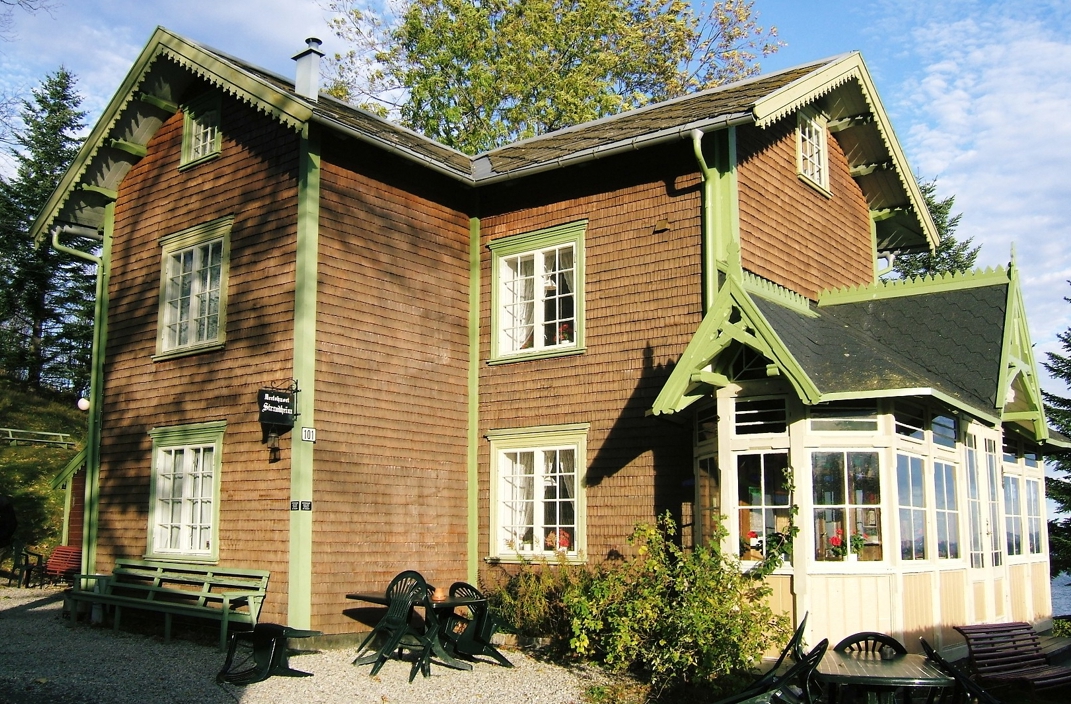 hus med sponvegger og dekorert glassveranda