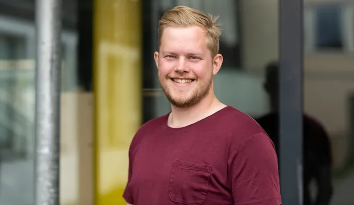 Portrett av kontaktlærer Sondre Brekke Valmork foran glassvegg