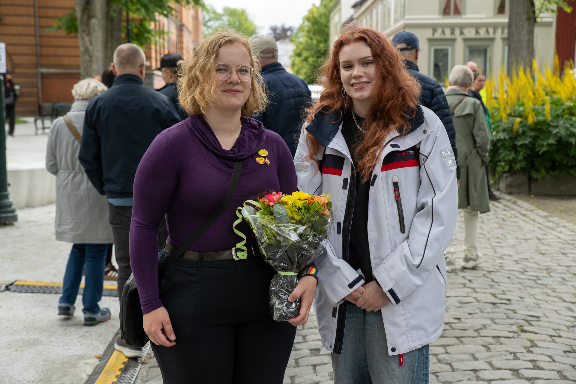 To damer fra Skeiv Ungdom med blomsterbukett