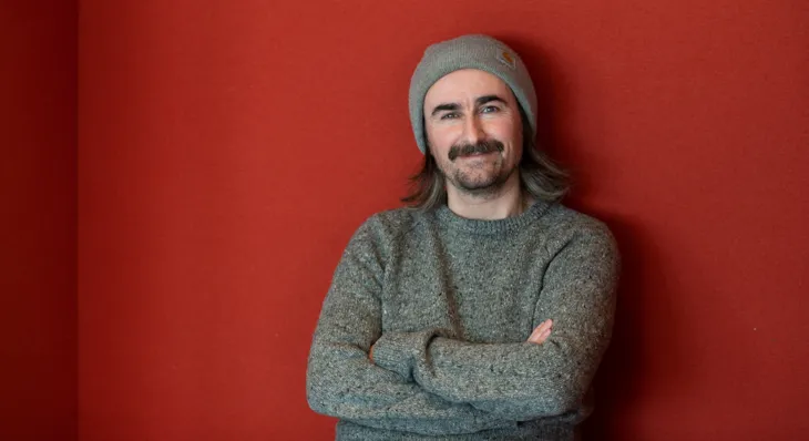 Foto av sosialpedagog Steffen Sandvær foran en rød vegg