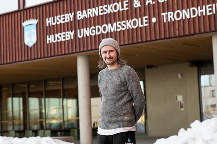 Sosialpedagog Steffen Sandv&aelig;r foran inngangspartiet til Huseby ungdomsskole
