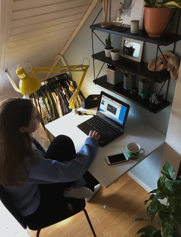 Bilde av Mina som sitter foran pcn sin på rommet sitt og har hjemmeskole.