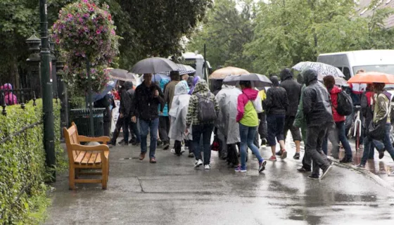 Foto av en gruppe mennesker i regnværet med paraplyer