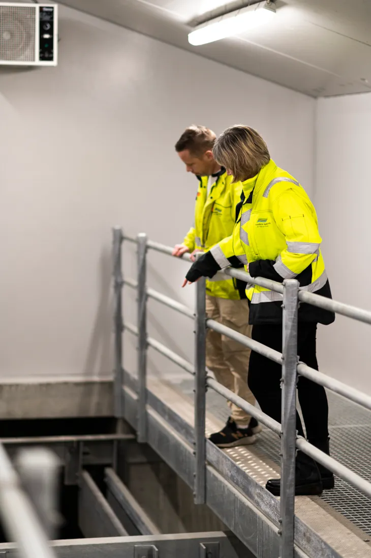 Cecilie og en kollega står inne i renseanlegget og inspiserer vannstrømmen.