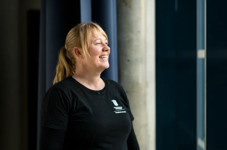 Foto av renholdsoperatør Maia Berg mens hun smiler og ser ut av vinduet