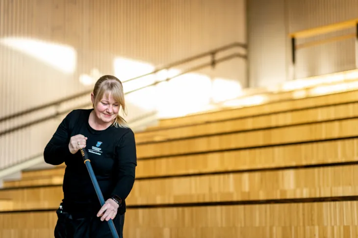 Foto av renholdsoperatør Maia Berg med mopp i amfiet på Spongdal skole
