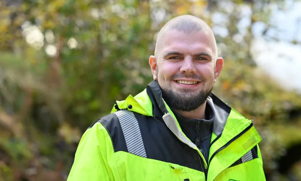 Portrett av arbeidsleder Andreas Foss Pedersen foran grønt buskas