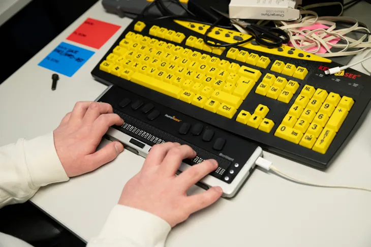Gult tastatur med st&oslash;rre tegn og h&oslash;yere kontrast og en leselist. 