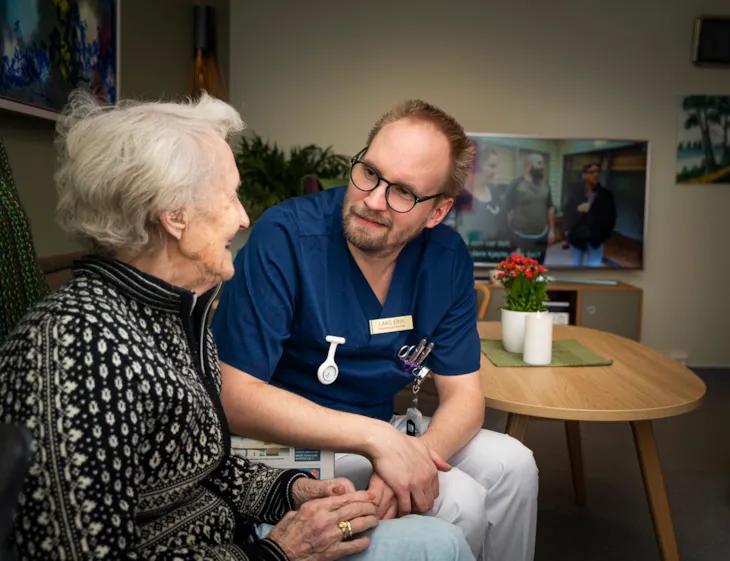 Helsefagarbeider Lars Erik snakker med eldre pasient