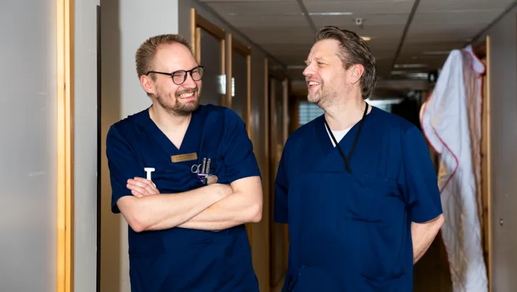 Helsefagarbeider Lars Erik sl&aring;r av en lystig prat med en kollega i gangen