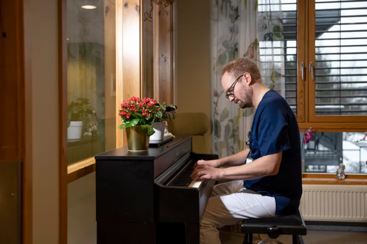 Helsefagarbeider Lars Erik sitter og spiller piano