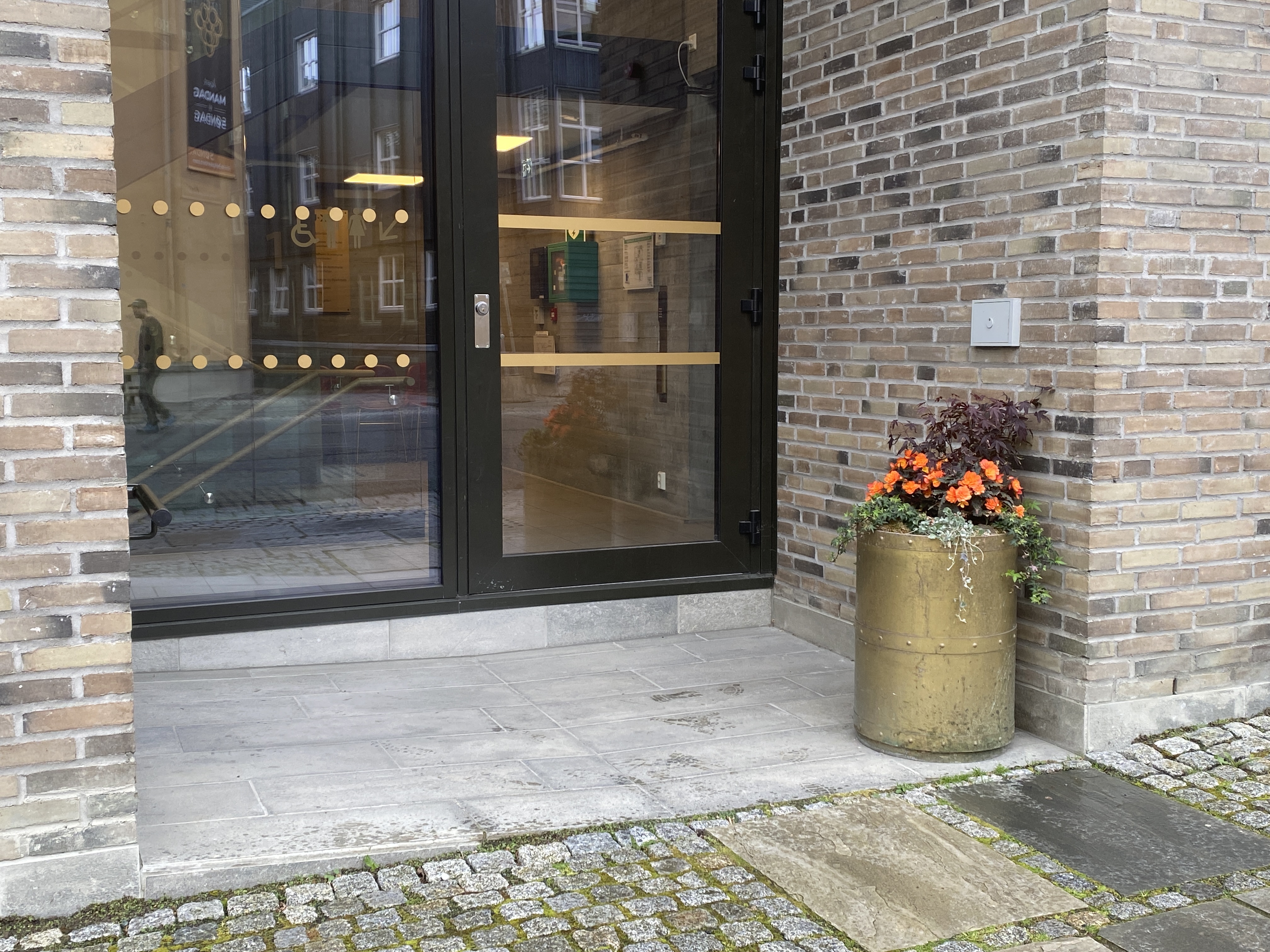 Blomsterkrukke i bunnen av rampe gjør forholdene litt trangerer for bruker