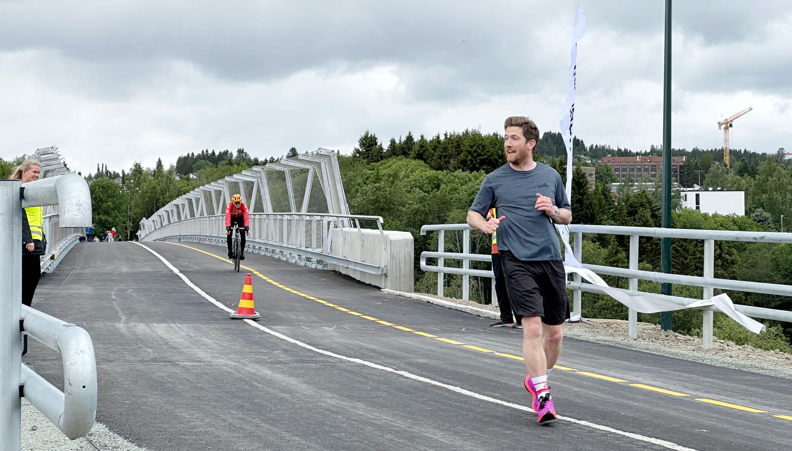 Mosjonist i mosjonisttøy som kommer joggende over bru