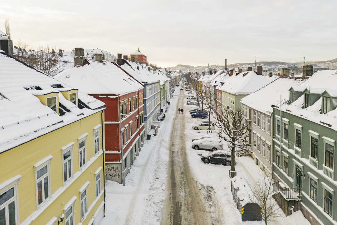 gat med trehus i to til tre etasjer, fargerike hus og snø