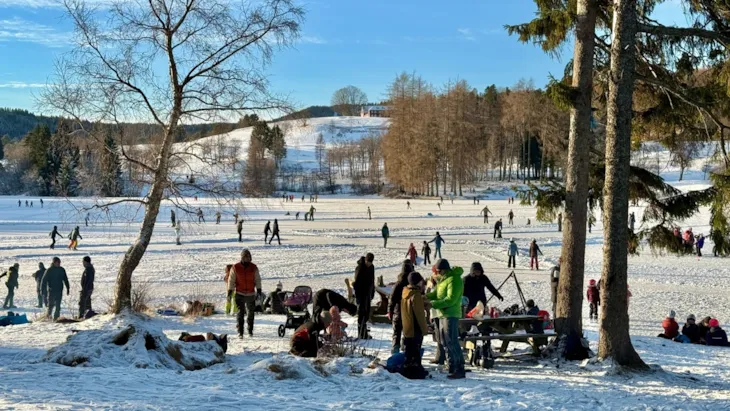 Bildet viser skøyteisen på avstand, der mange er ute på skøyter.