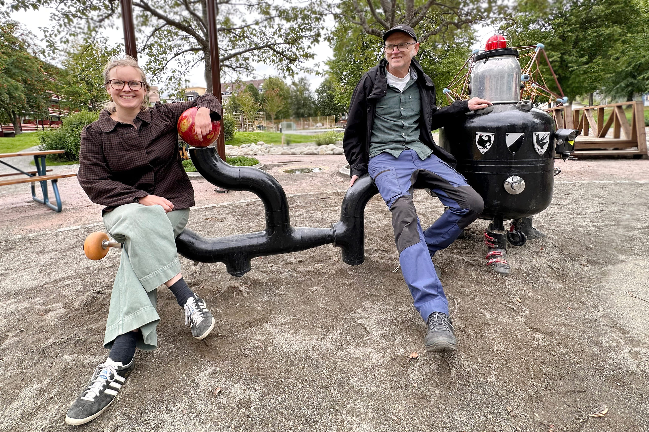 To personer som sitter på lekeapparat