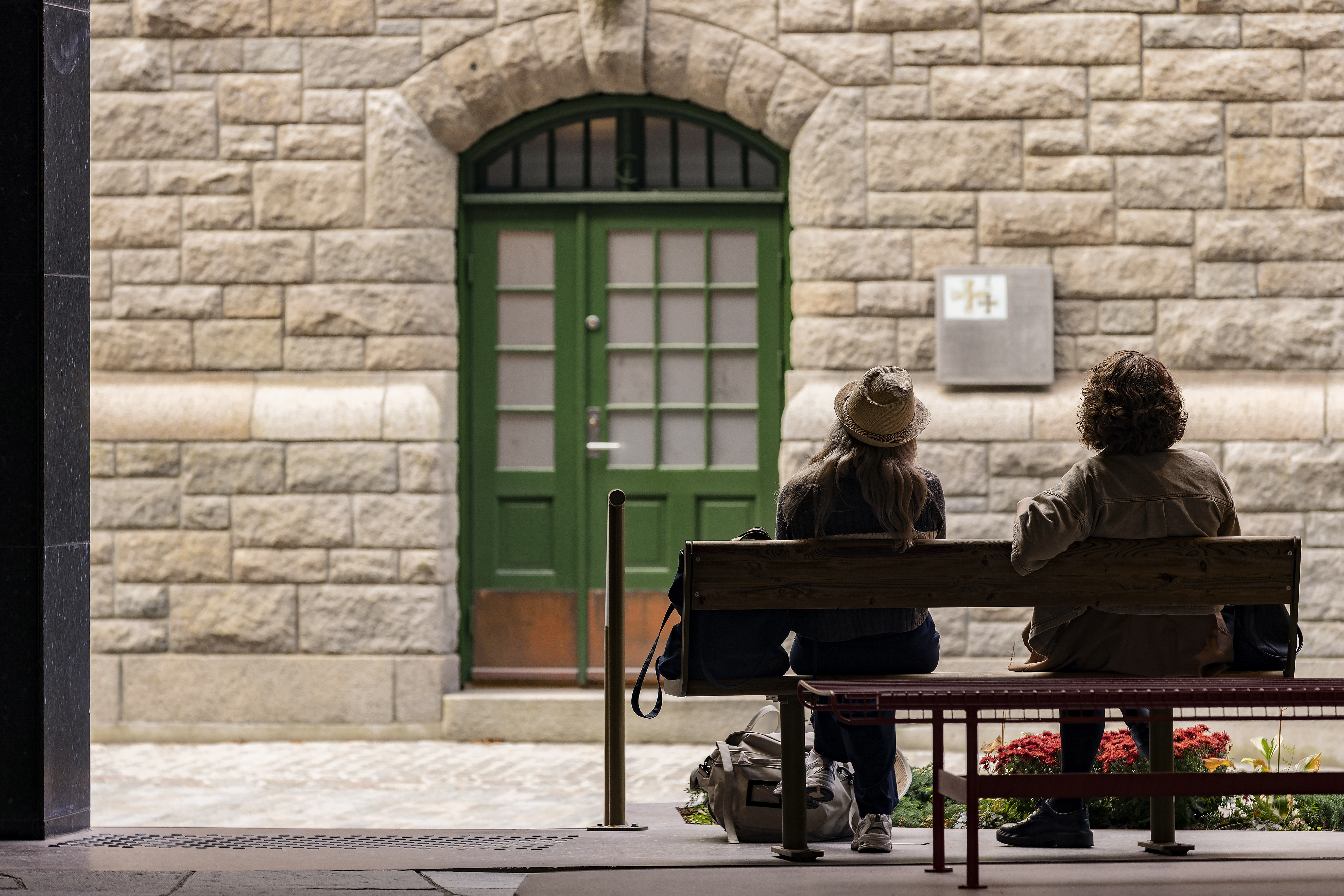 2 personer som sitter p&aring; en benk i passasjen