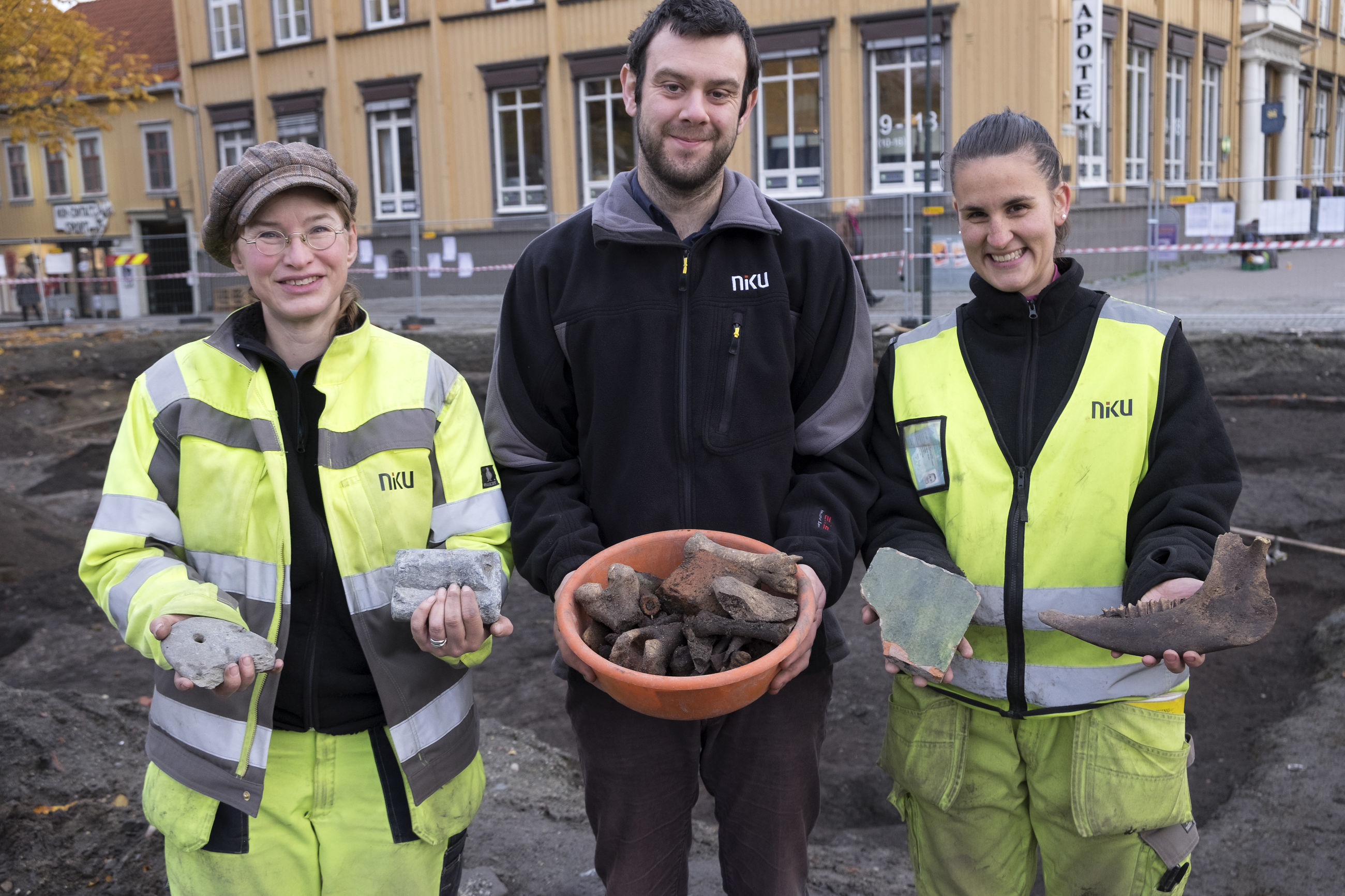 Tre personer som holder gjenstander i hendene foran seg