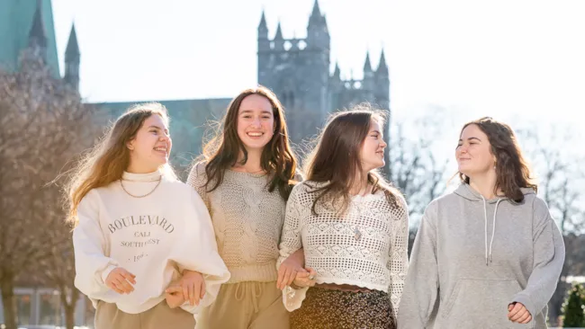 Fire medelever foran Nidarosdomen i sollys.