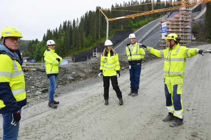 Bilde fra befaring i Granåsen idrettspark 23. juni 2022. Fra venstre: kultur- og idrettsdirektør Ola By Rise, enhetsleder Knut Kvaran, utbyggingsleder Mona Åsgård, prosjektutvikler Stein Ove Brandslet og prosjektleder Svein Arne Henriksen (NCC). I bakgrunnen ser vi unnarennet på begge Granåsbakkene.