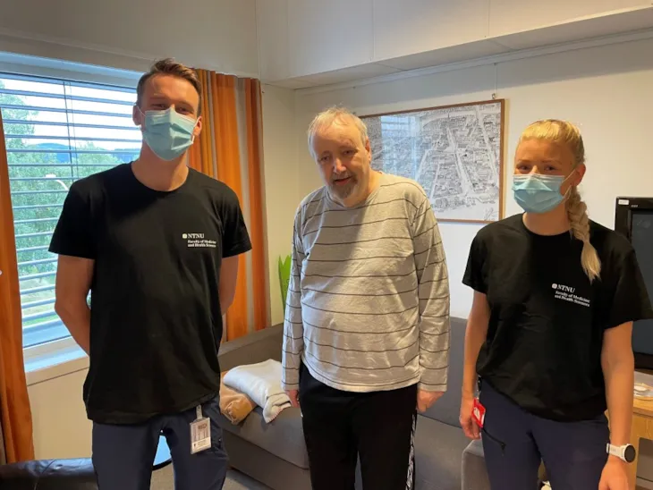 Bilde av Vemund Øvstehage og Stine Øverengen Trollebø fra NTNU sammen med beboer Johan Schelvan