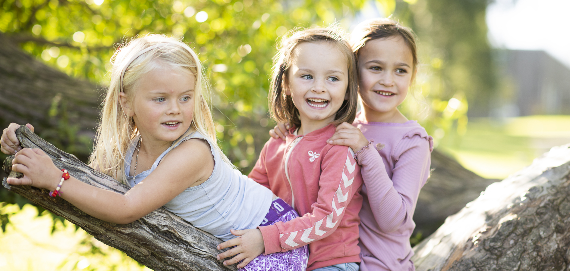 Tre barn leker sammen i et tre