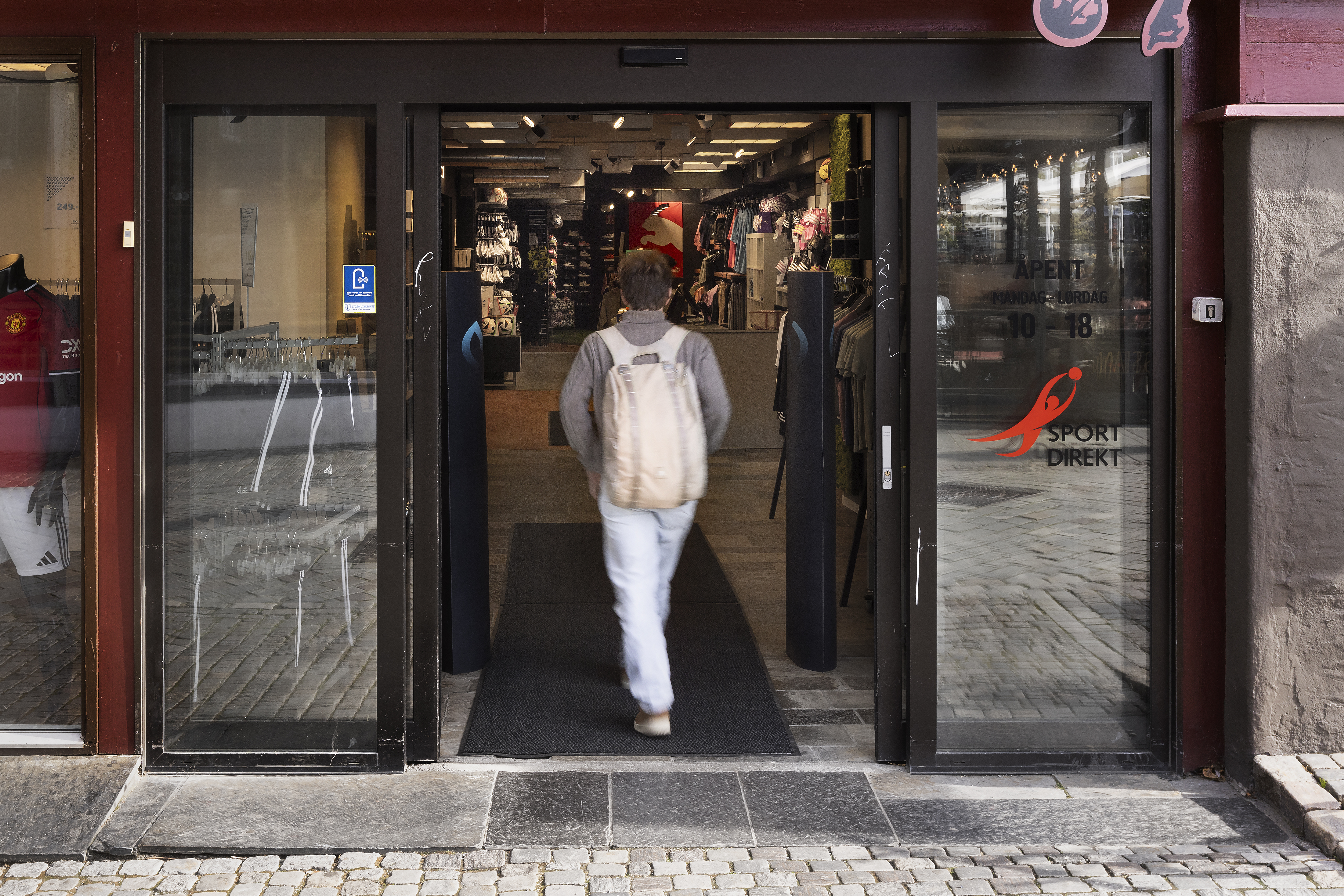 person som g&aring;r inn i butikken . Viser ogs&aring; dekket utformet med skiferheler utenfor d&oslash;ren
