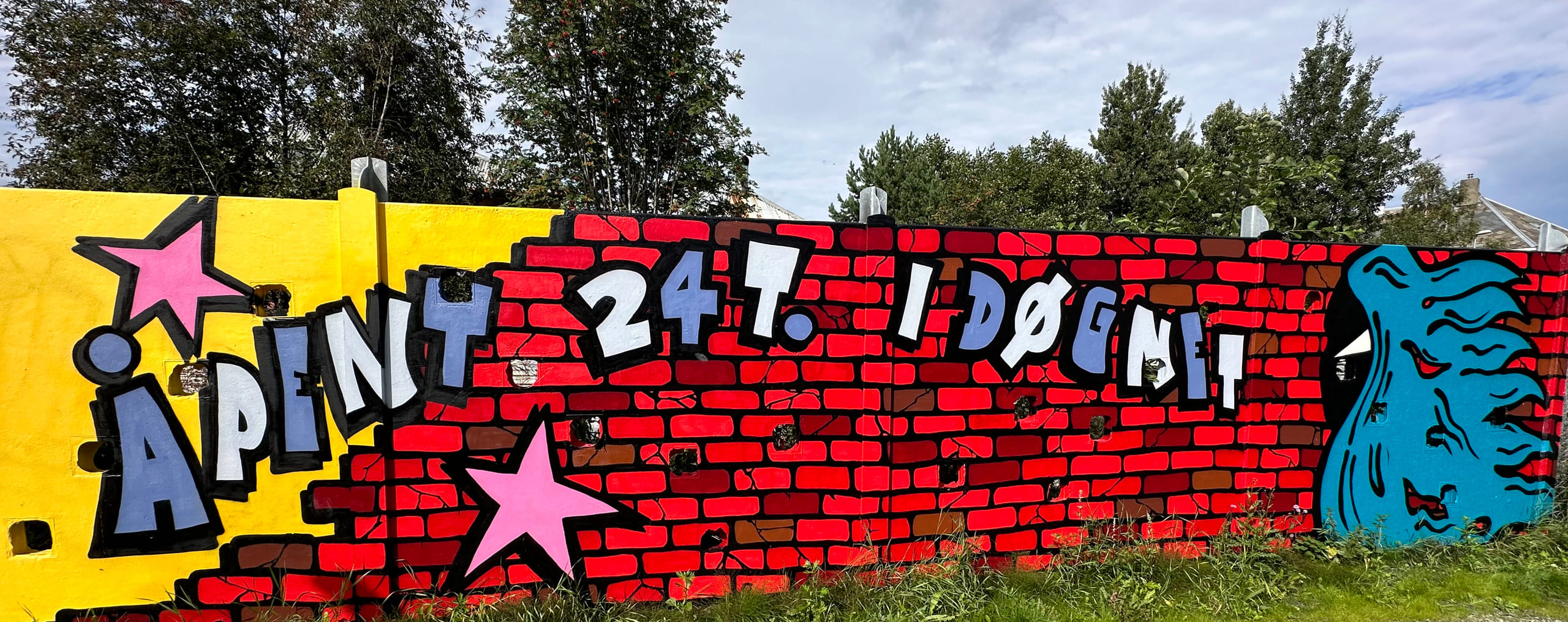 Murvegg som er tagget med "Åpent 24 timer i døgnet".