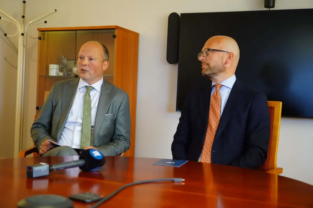 Kjetil Reinskou og Kristian Dahlberg Hauge sitter ved et bord med en mikron på bordet