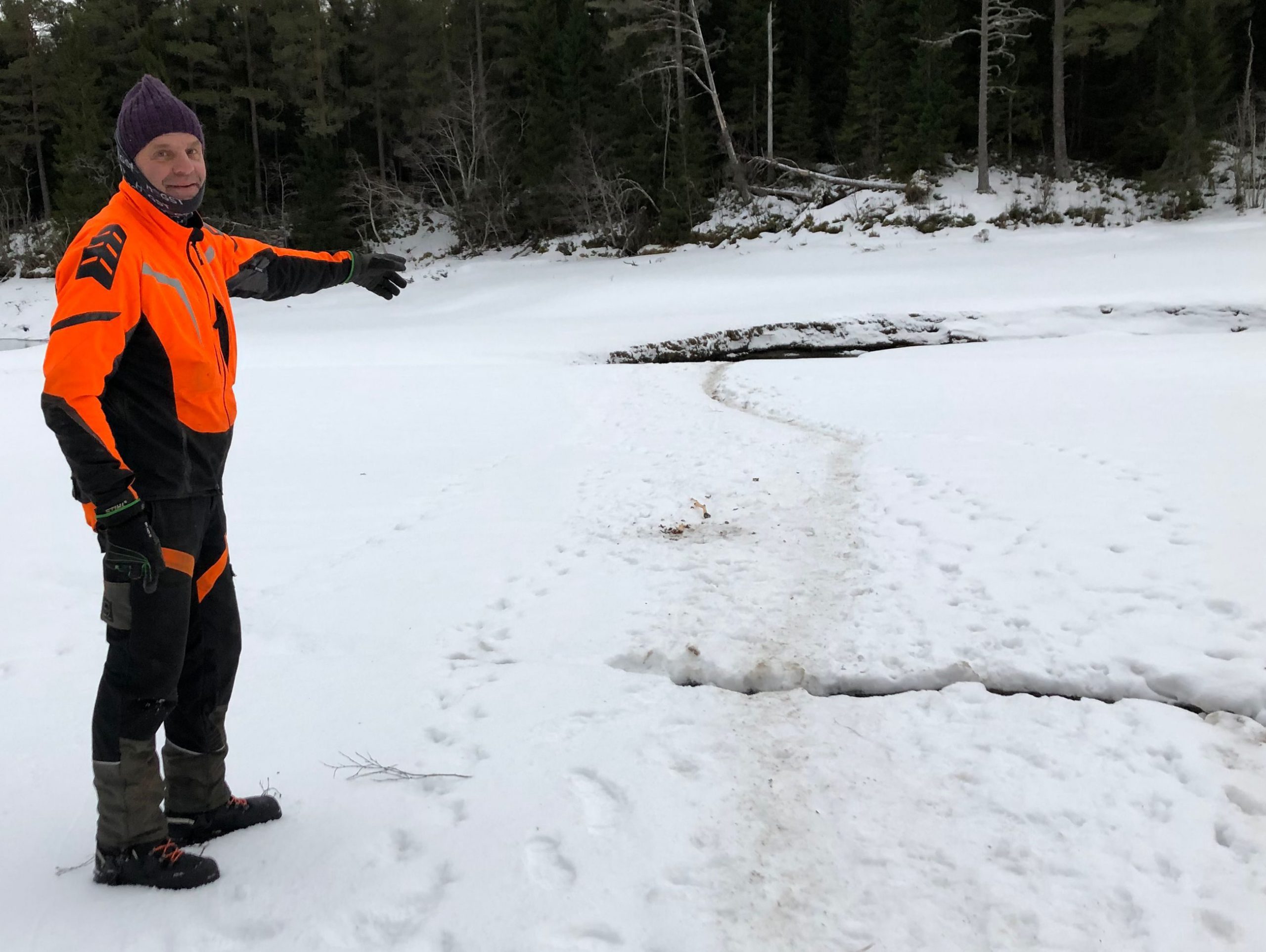 Mann st&aring;r i sn&oslash;en og peker