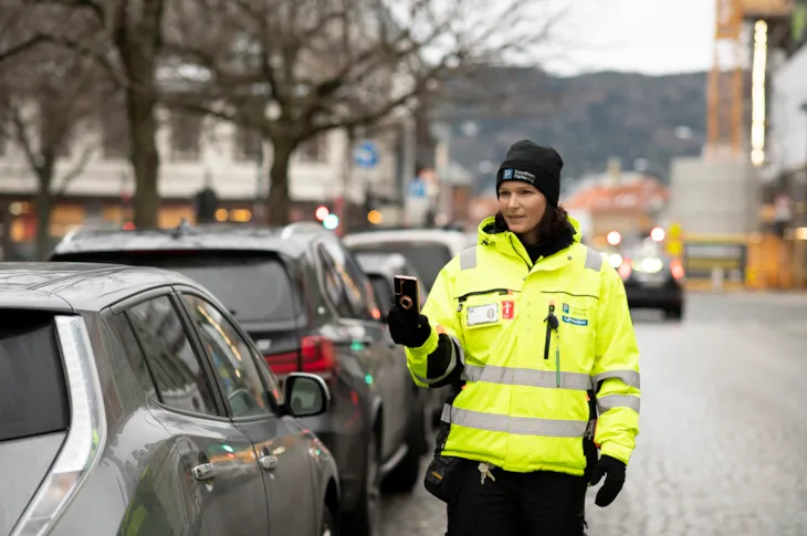 Foto av trafikkbetjent Marie i Dronningens gate mens hun scanner en bil