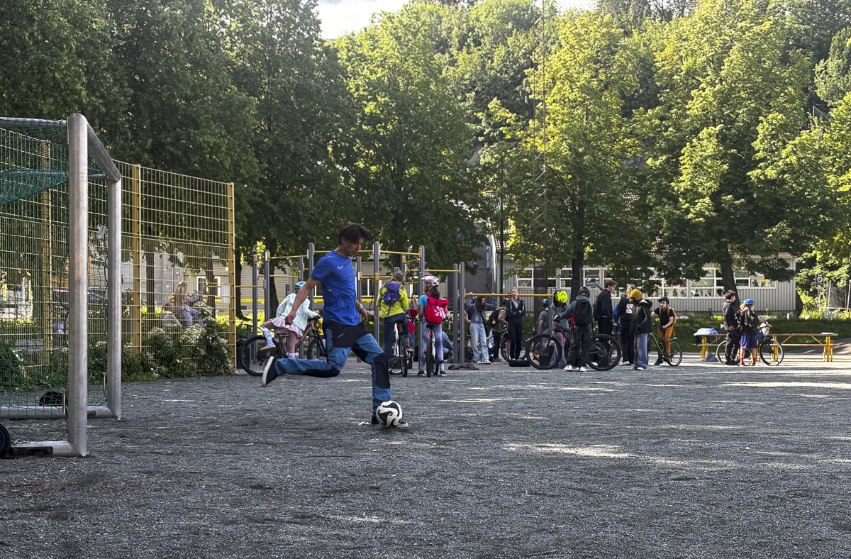 Gutt i bl&aring; skjorte sparker ball