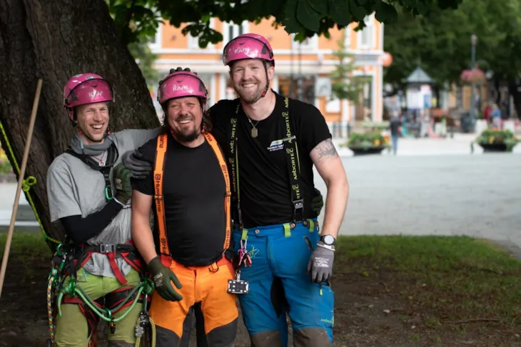 Martinus, Fredrik og Christian st&aring;r foran et tre, i f&oslash;rt rosa hjelmer og fargerike bukser. De ser alle i kamera og stemningen er god.