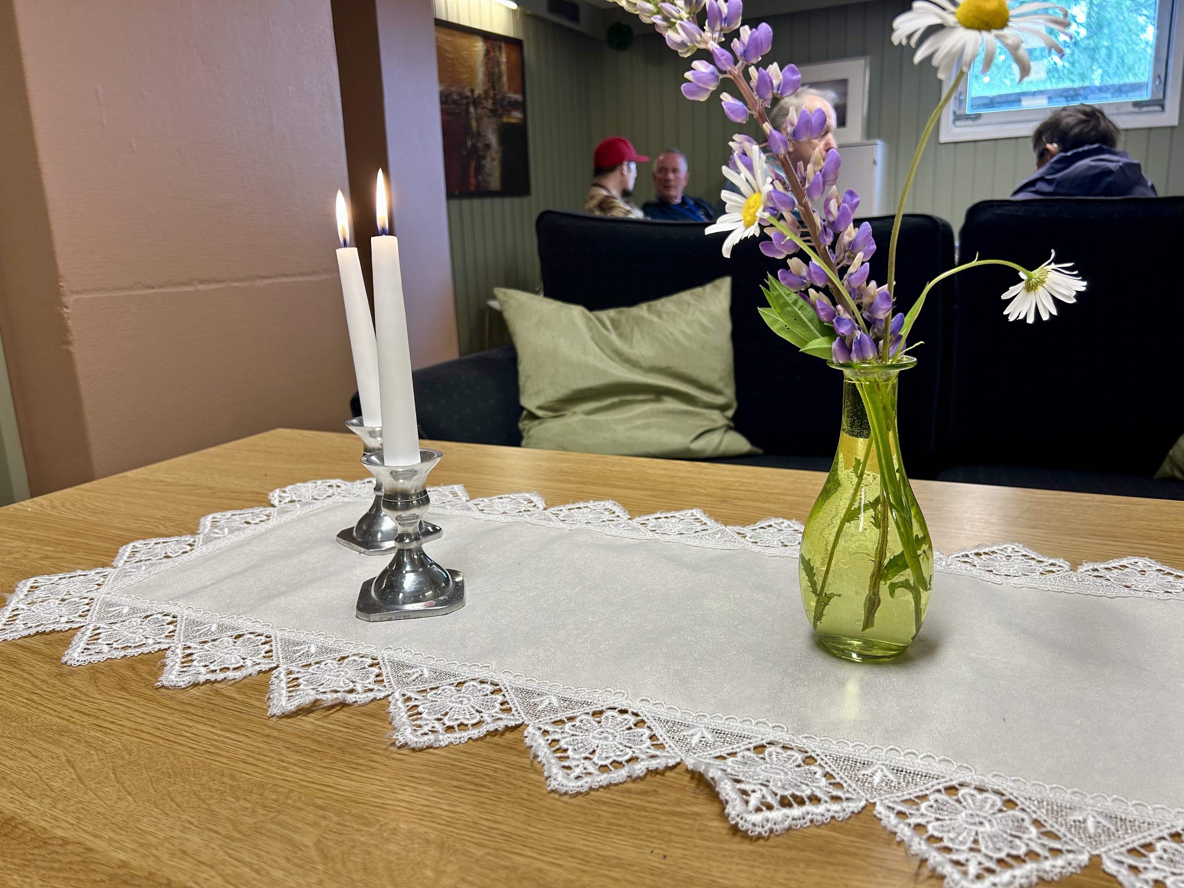 Tente lys og blomster pynter opp p&aring; bordet