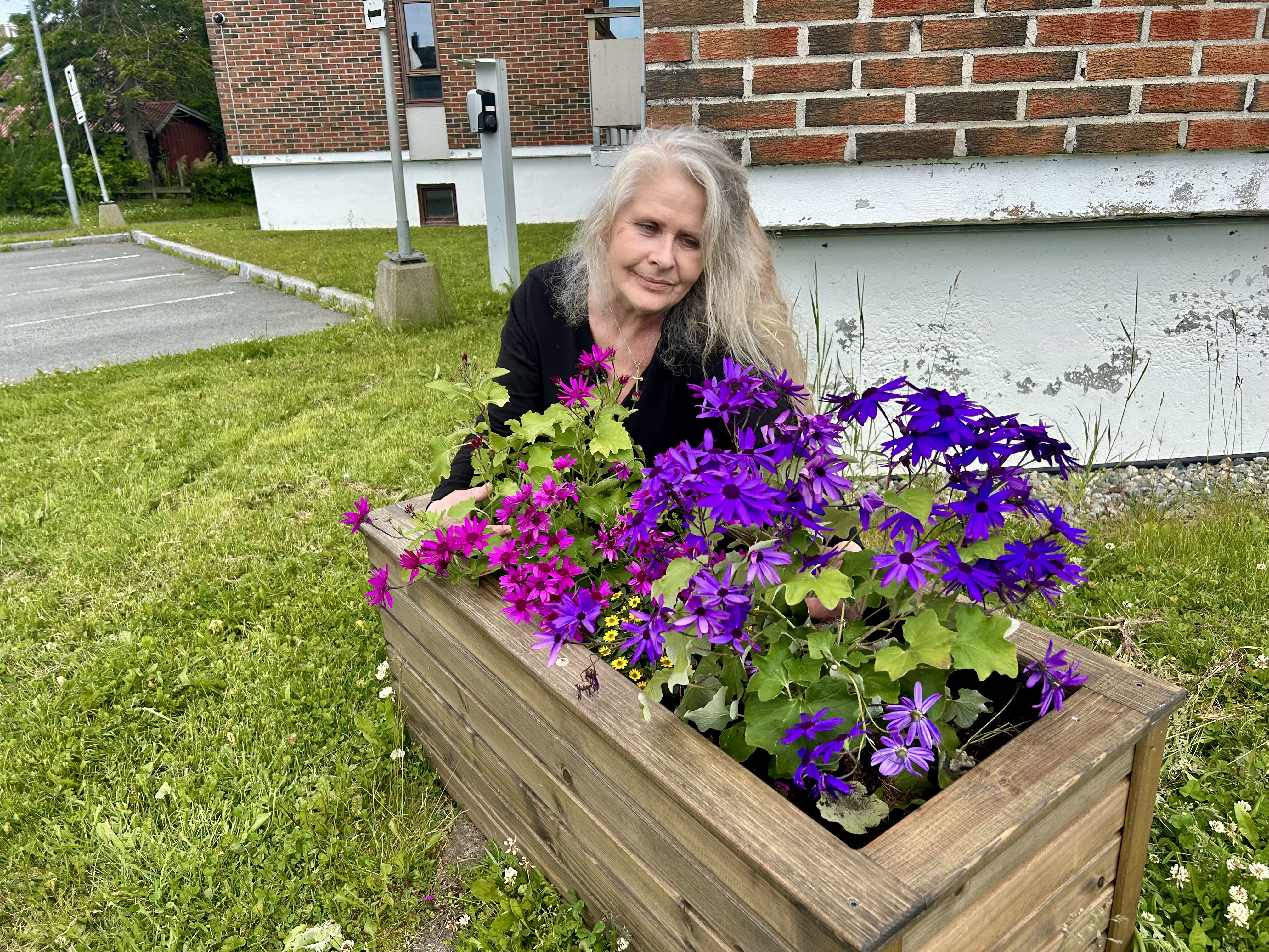 Monicha, en av beboerne planter blomster