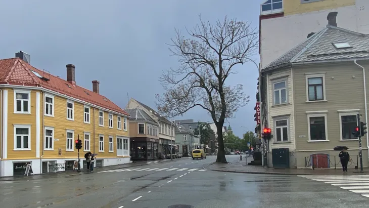 Et gatekryss med trebygg i rekke på hver side av veien