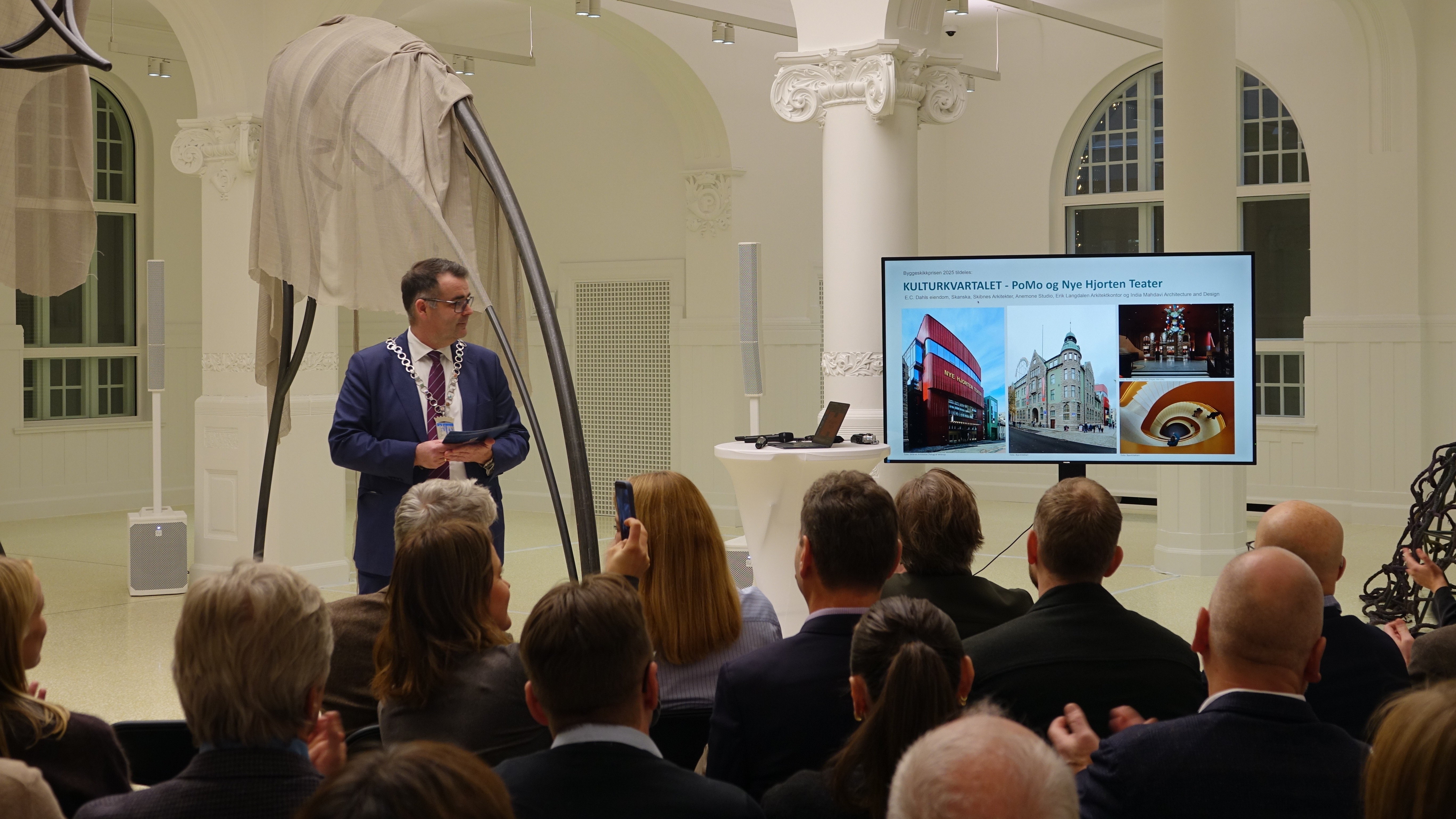 Ordfører Kent Ranum deler ut Byggeskikkprisen 2025 i lokalene til PoMo