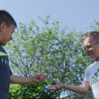 To barn holder frem hender i leken stein saks papir