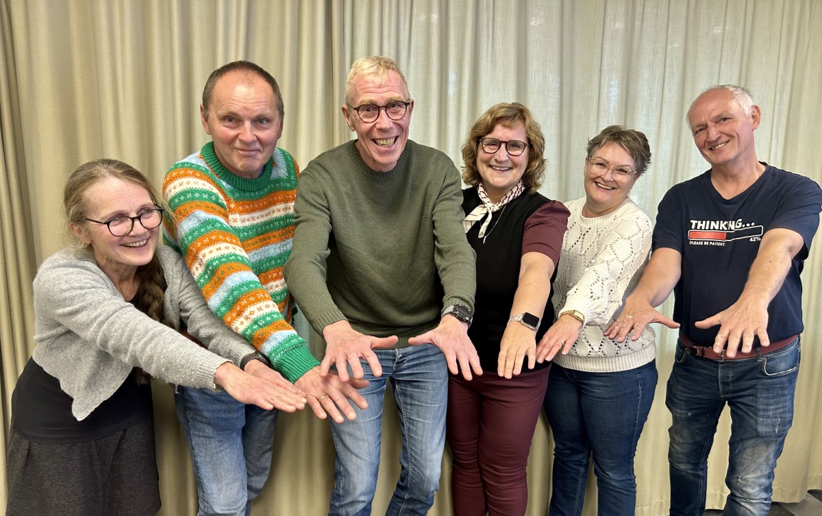 Tre menn og tre kvinner står sammen og rekker hendene fram. i en gruppeSeks Fem