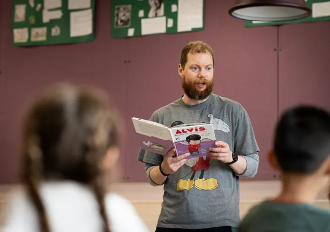 Lærer som leser høyt for elever ved Nidarvoll skole.