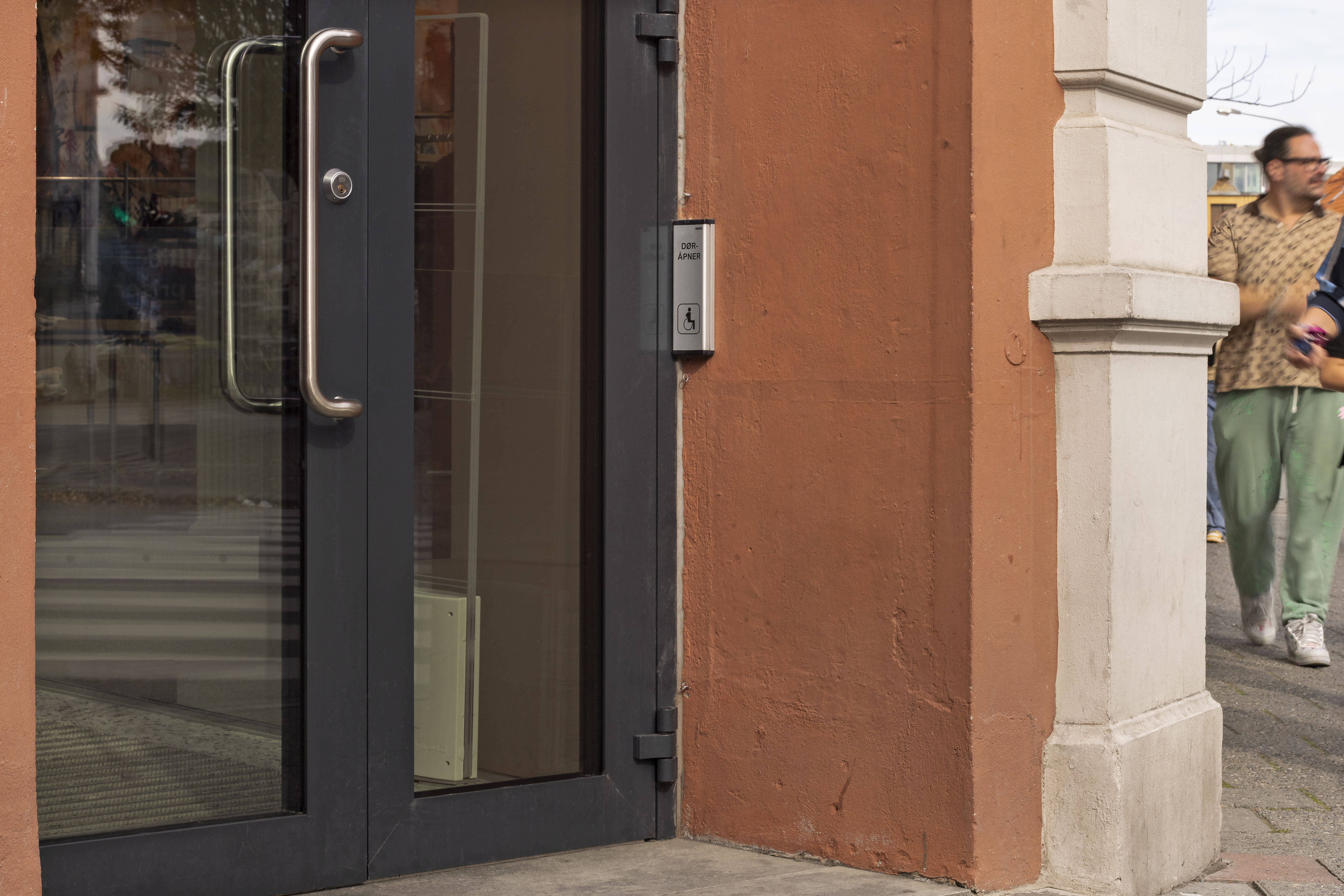 n&aelig;rbilde av d&oslash;r med bryter for d&oslash;r&aring;pning plassert i hj&oslash;rnet p&aring; h&oslash;yde side av d&oslash;r