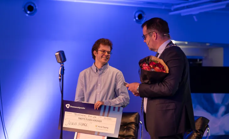 Mottaker av drømmestipendet, Jonas Støre, sammen med ordfører Kent Ranum på scenen.