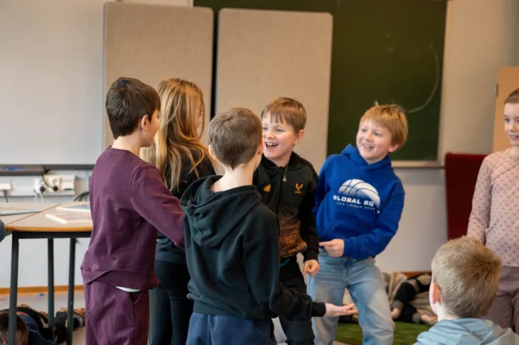Seks barn i 8-årsalderen leker og ler.