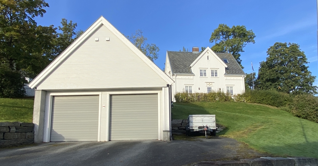 dobbel garasje med saltak i hvit trekledning