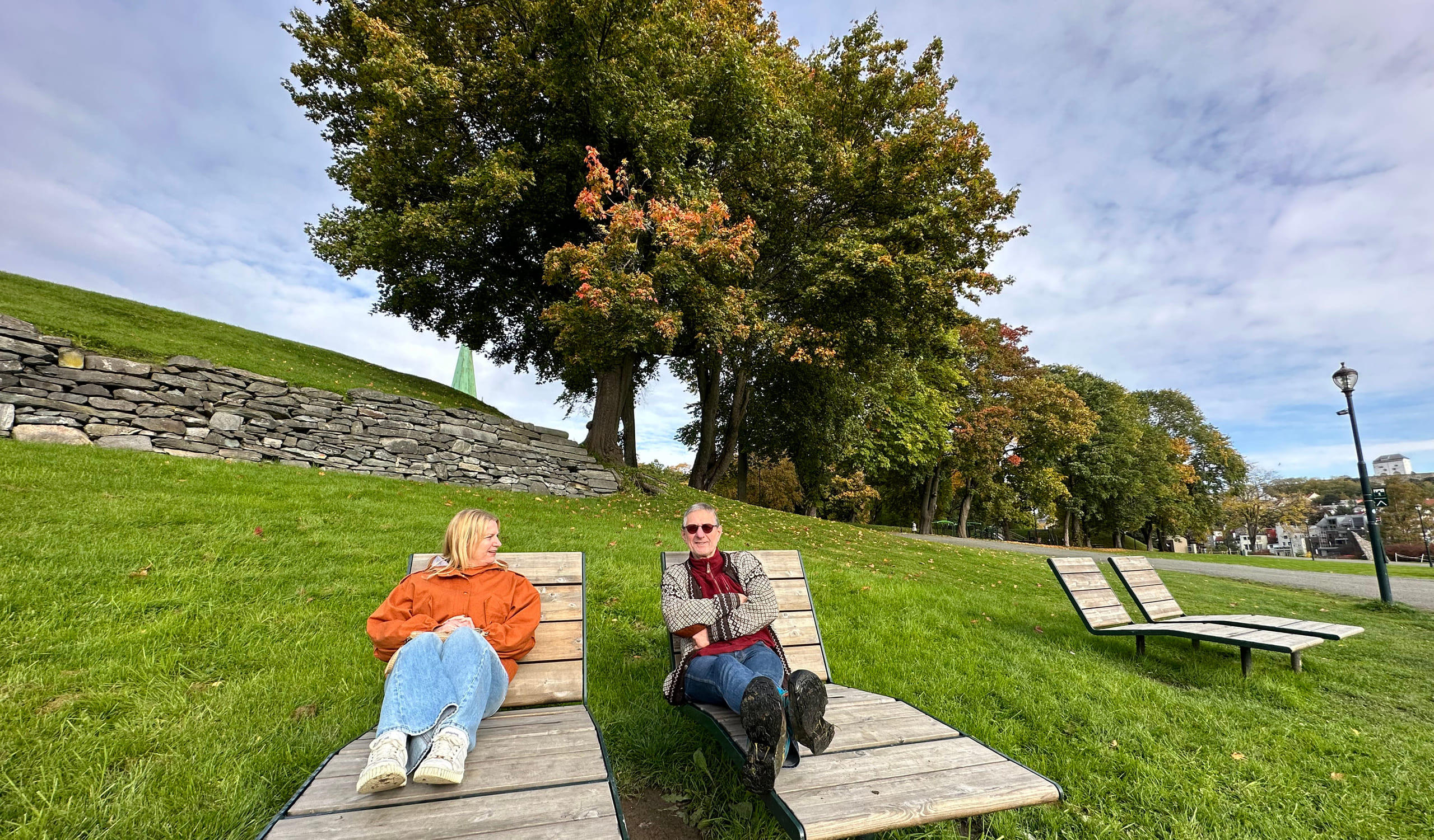 To personer sittende på hver sin solseng på Marinen
