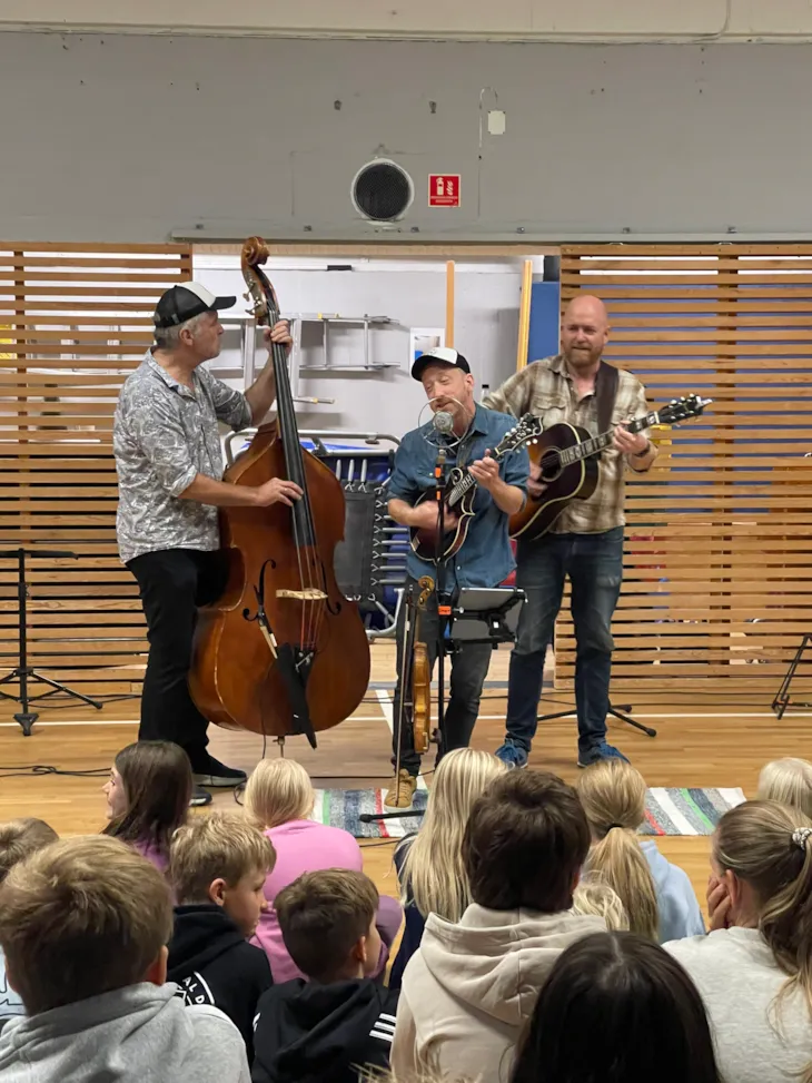 Tre menn som spiller og synger