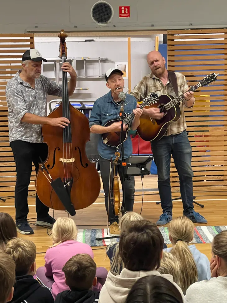 Tre menn som spiller og synger