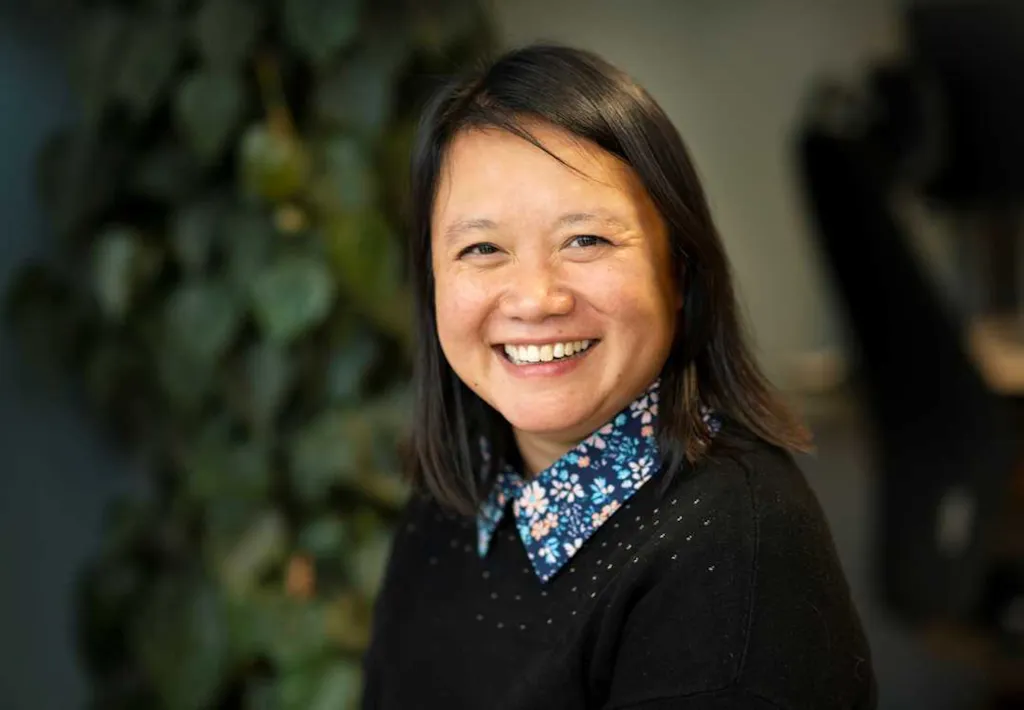 Portrett av avdelingsleder Phuong Pedersen foran en stor plante